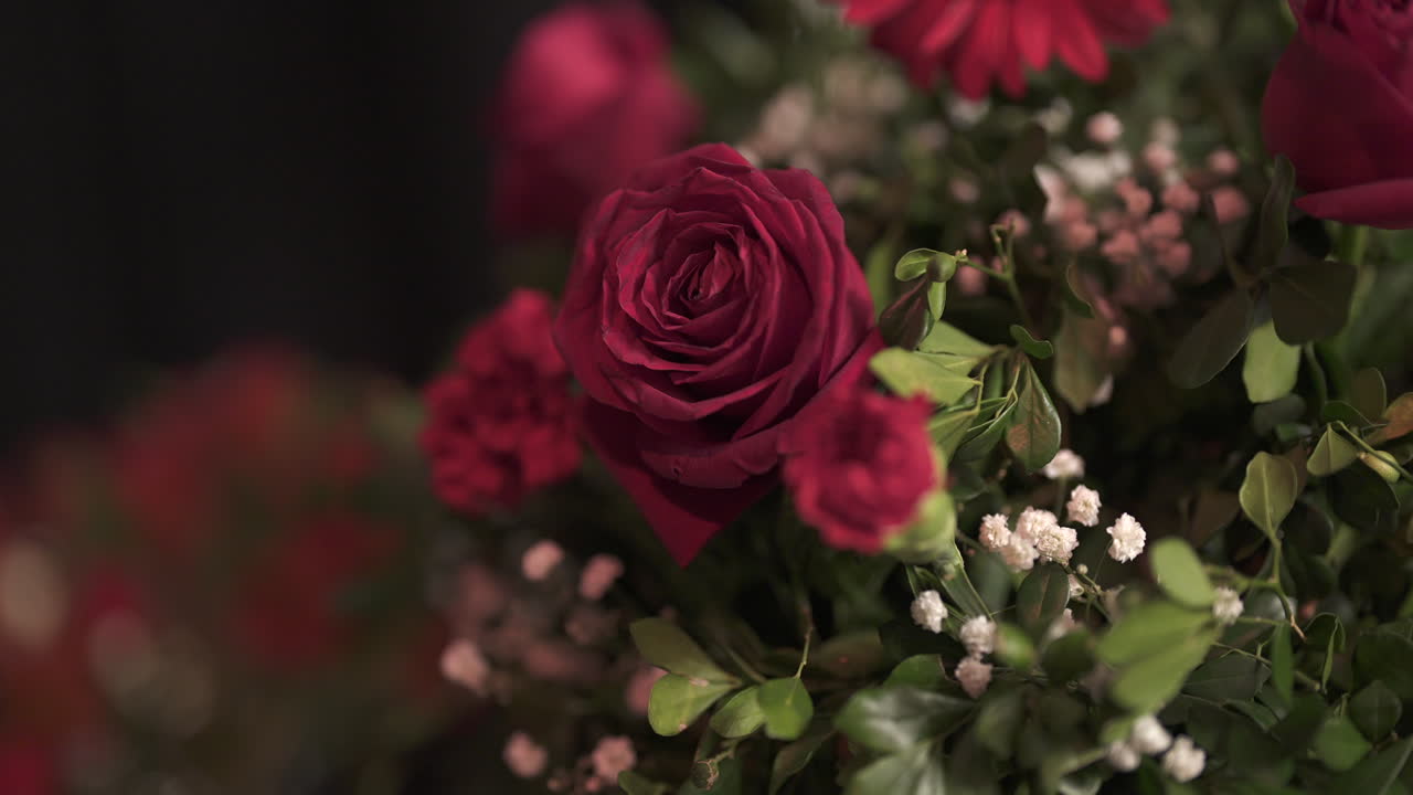 un ramo de rosas rojas vibrantes y flores con hojas verdes exuberantes, que simbolizan el amor