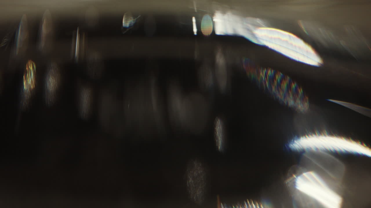 Close up of a clear glass of water on a table, with soft reflections and light refractions