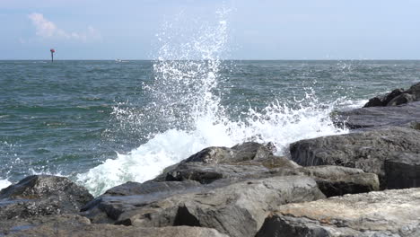 a slow motion video clip of ocean waves breaking on a rock jetty