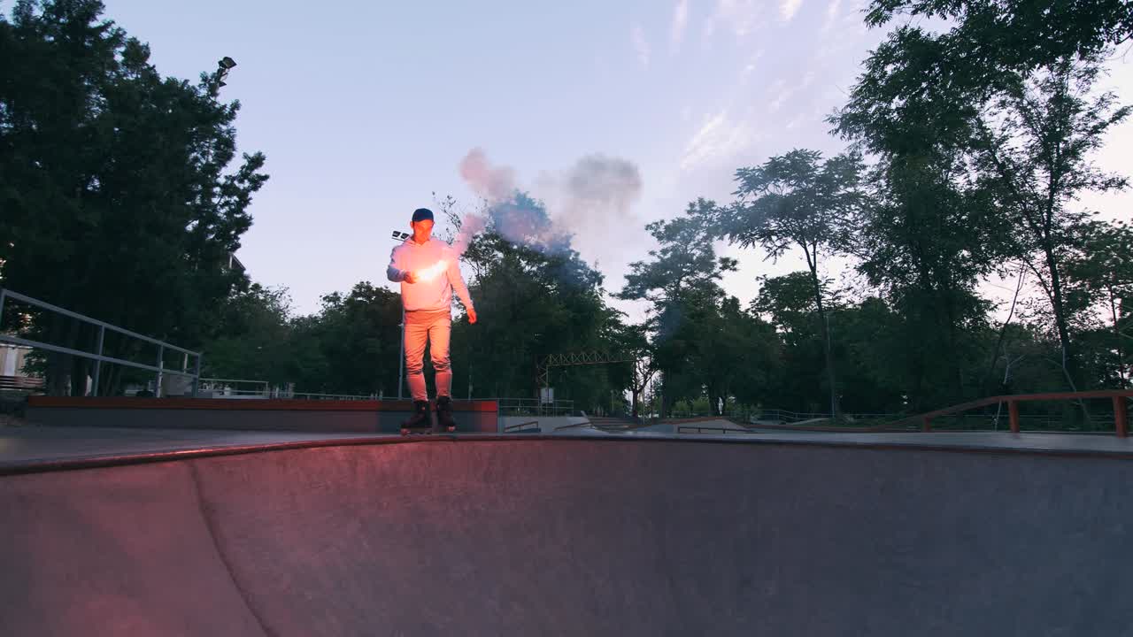 patinador de rodillos en línea agresivo haciendo trucos en el skatepark de hormigón con señal de quema roja al aire libre, cámara lenta