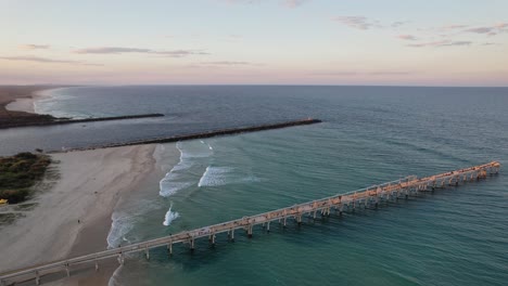 aerial view of sand pumping jetty at the spit on the gold coast in queensland, australia at sunset - drone shot