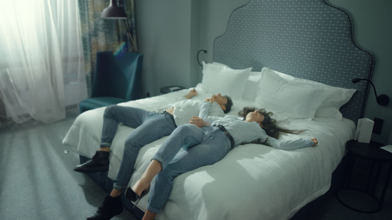 매력적인 커플이 침대에서 휴식을 취하고, 귀여운 남녀가 호텔에서 휴가를 즐기고 있다.