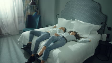 aantrekkelijk paar rusten op bed. leuke man vrouw genieten van vakantie in het hotel.