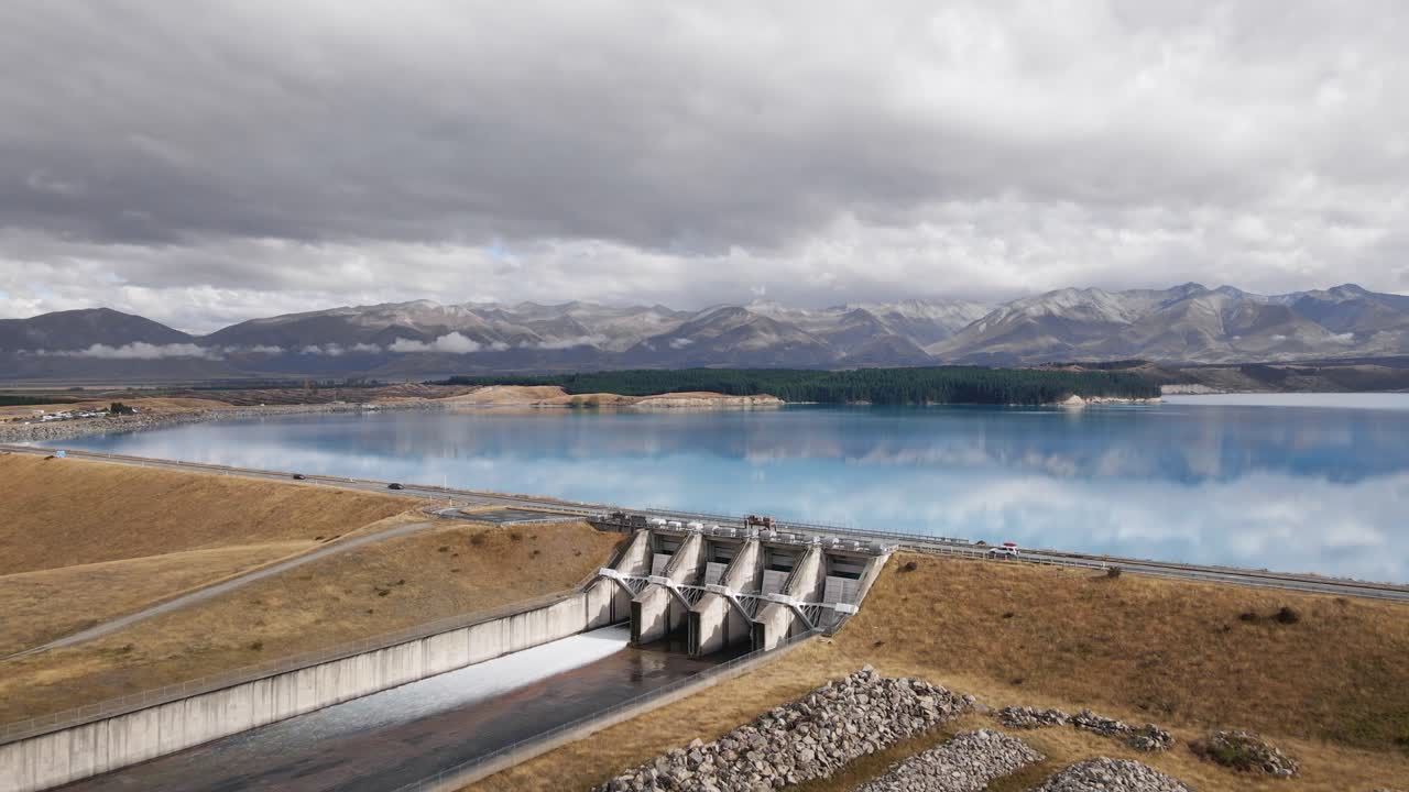 Spilling dam at clear blue artificial lake in New Zealand