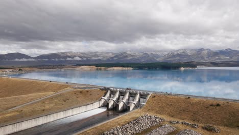 spilling dam at clear blue artificial lake in new zealand