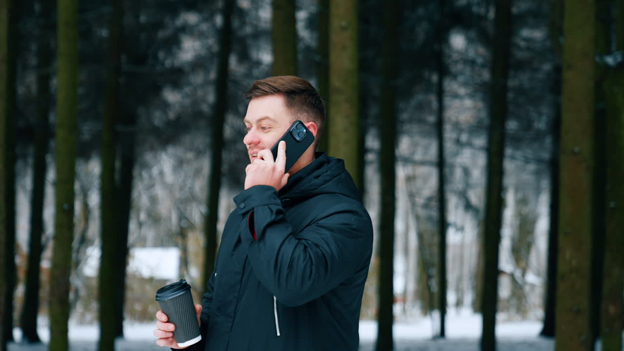 Business conversation outdoors. Man solving business issues remote walking in winter park and drinking coffee.
