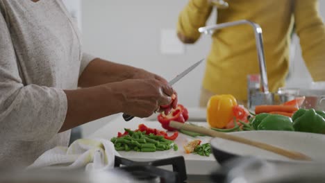 a senior african american couple cooking at home. social distancing in quarantine