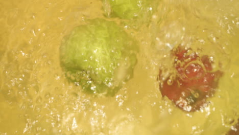 primer plano de manzanas con diferente color cayendo en el agua