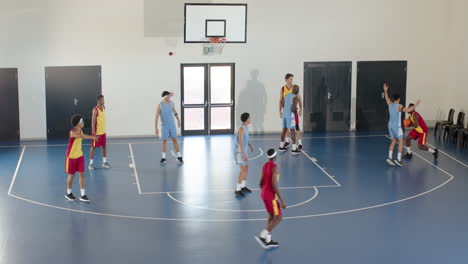 players competing in intense basketball game on indoor court, focused and determined