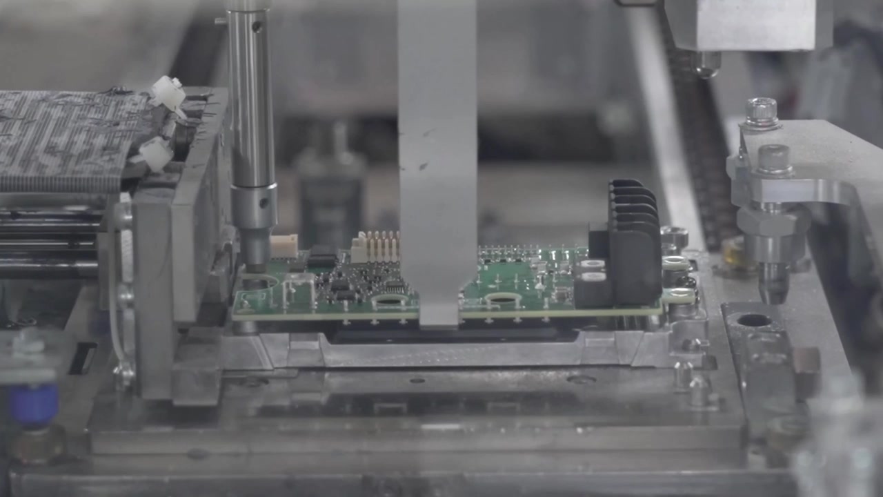 Automated testing and pressing machine processing small PCB board with precision fixture in electronics factory