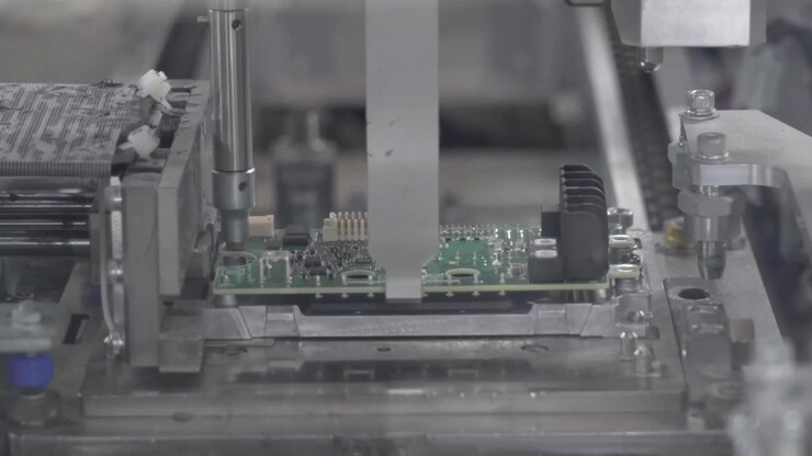 Automated testing and pressing machine processing small PCB board with precision fixture in electronics factory