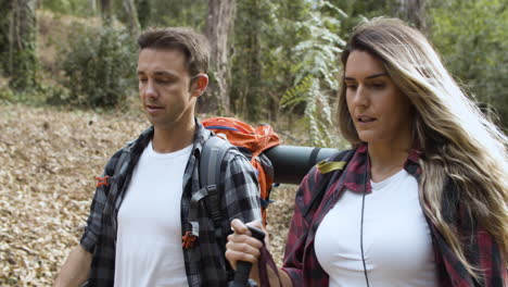 casal de turistas conversando enquanto carregava mochilas de acampamento