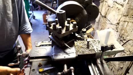 close up or milling machine in action. unrecognizable turner working with old workbench in his garage or workshop. mechanic using lathe for metal processing. slow motion