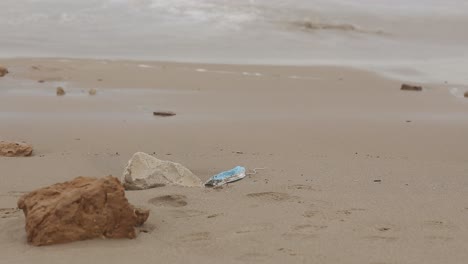 dirty medical mask on sandy seashore