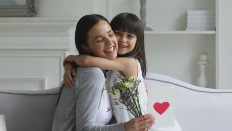 cute little kid daughter congratulating happy mom with mothers day