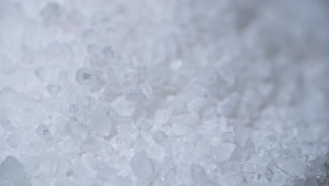 an extreme close-up macro shot of coarse sea salt crystals. the irregular shapes and translucent texture of the salt grains are highlighted, creating a detailed and natural composition.