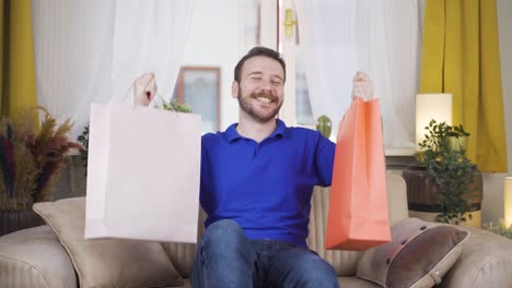 hombre mirando a la cámara con bolsas de compras.