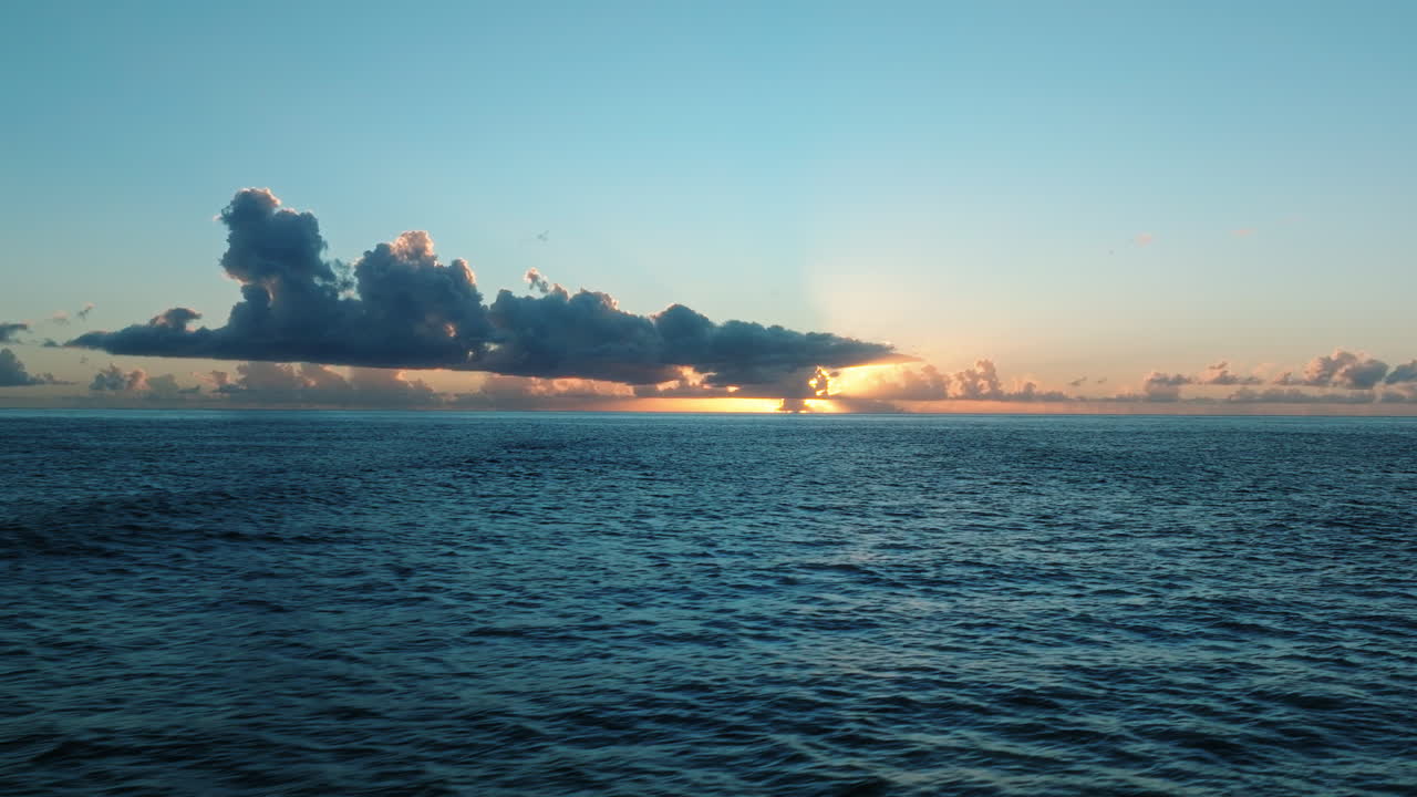 FPV drone gliding above ocean filming sunset and clouds over Guadeloupe waters