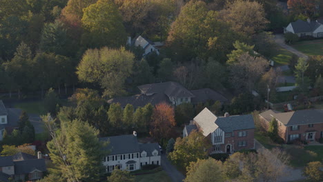 flyover-nice-houses-with-a-street-and-a-bit-of-a-golf-course-at-golden-hour-in-Autumn