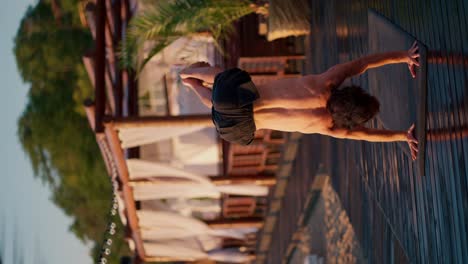 the guy gets to his feet during a yoga class on the beach. harmony of body and mind