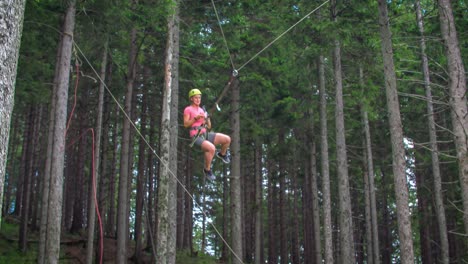 slow motion of young female swinging to and fro and clicking selfies on a big hanging swing between trees