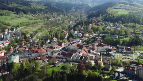 aerial reveal of a picturesque old european town located among green hills