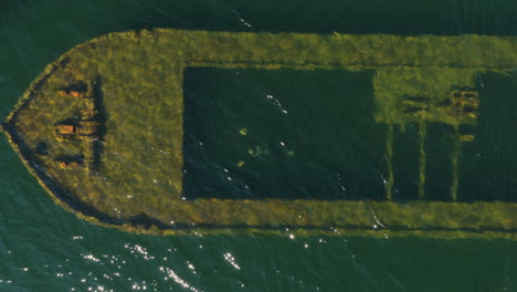 birds eye drone shot of a diver swimming at a shipwreck at lake saimaa, finland