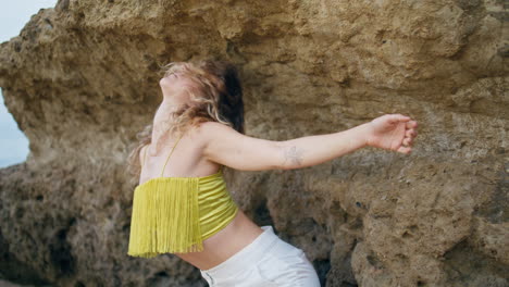 contemporary performer dancing sensual dance at rocky shore closeup. girl dancer