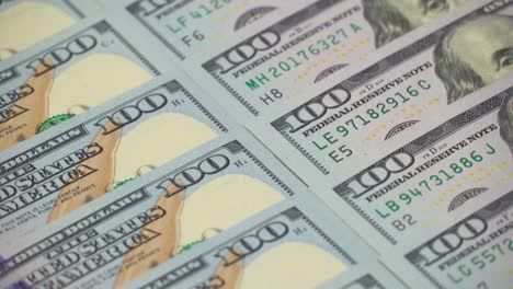 many dollars dollars dollars closeup. the camera spans from above over evenly placed bills. 100 dollars