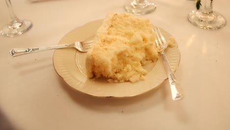 slice of white wedding cake with forks