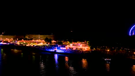 wine fair at night illuminated with large crowds in bordeaux france, aerial dolly in shot