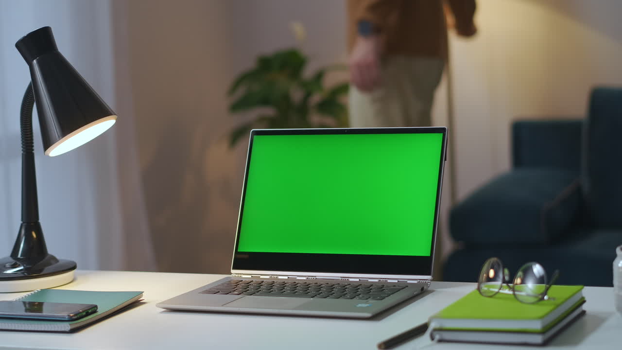 portátil con pantalla verde en la mesa de trabajo en la oficina de casa hombre está apagando la mesa y las lámparas de piso en la sala de estar y cerrando la cubierta tecnología de llave croma