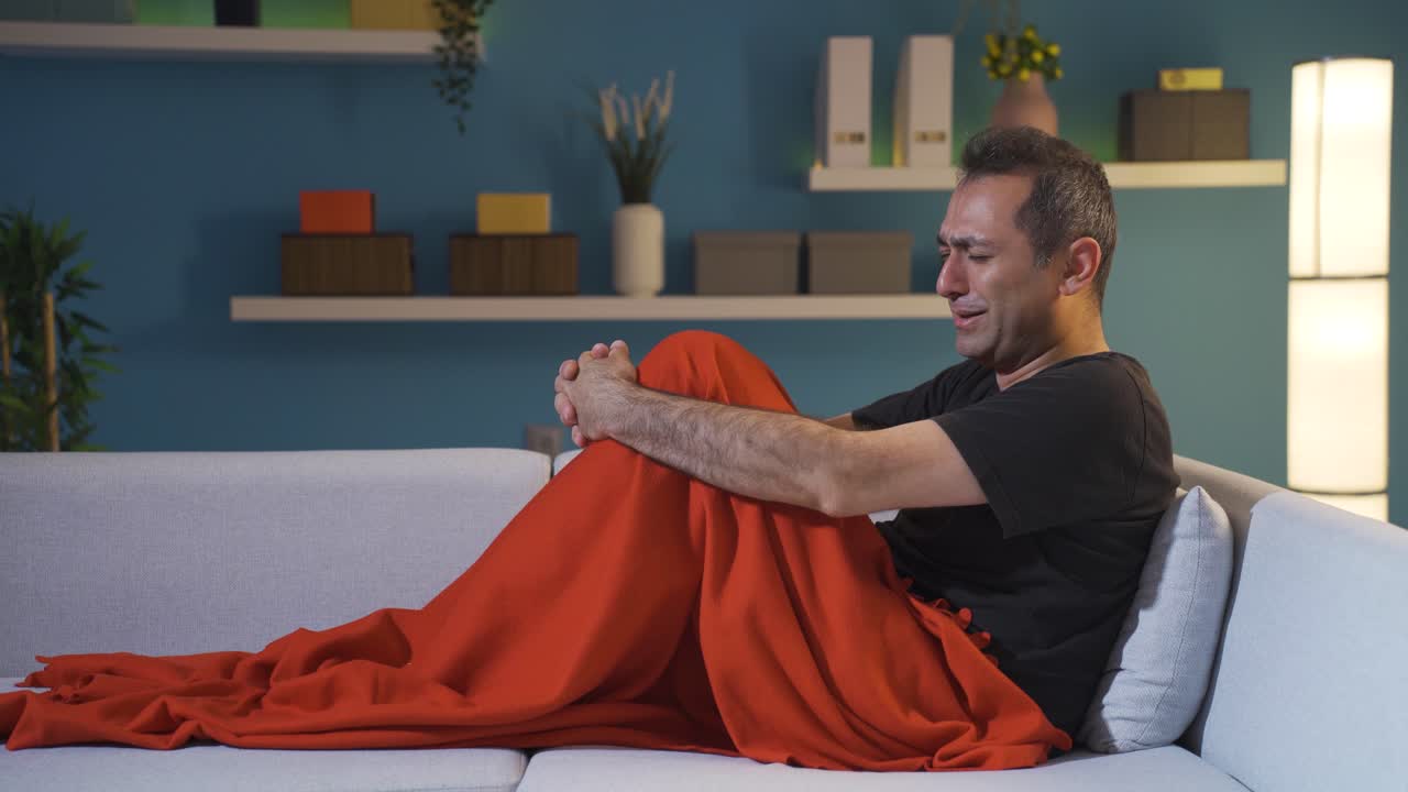 침대에서 불행하게 울고 있는 남자.