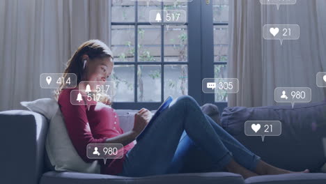 using tablet on couch, woman surrounded by social media notifications animation