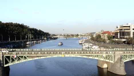 Aerial-Shot-Of-Cars-Driving-On-A-Bridge-Over-River-In-Beautiful-Prague,-Czech-Republic