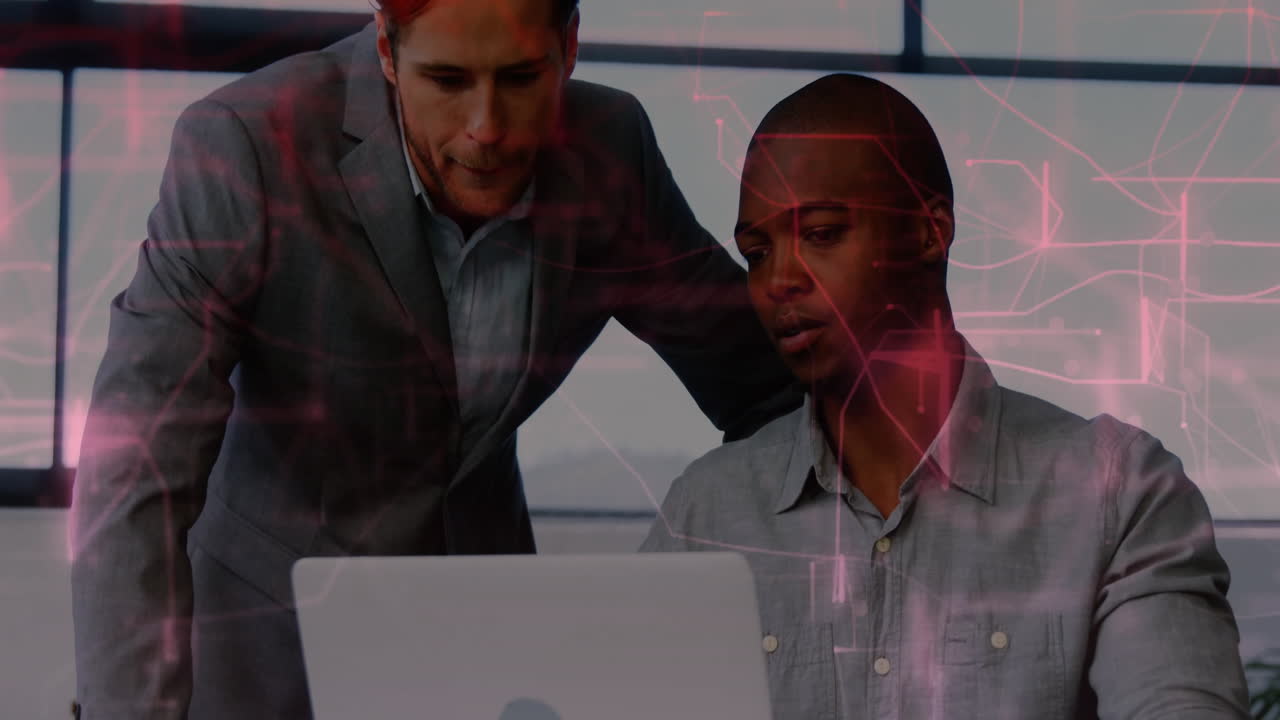 Two men collaborating on laptop with digital network animation overlay