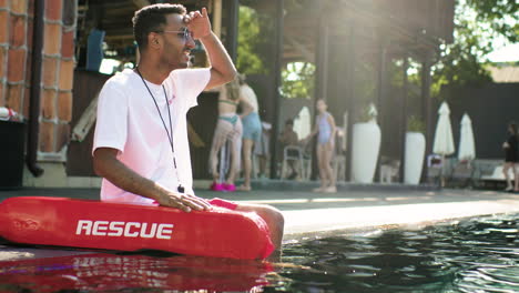 sauveteur assis au bord de la piscine