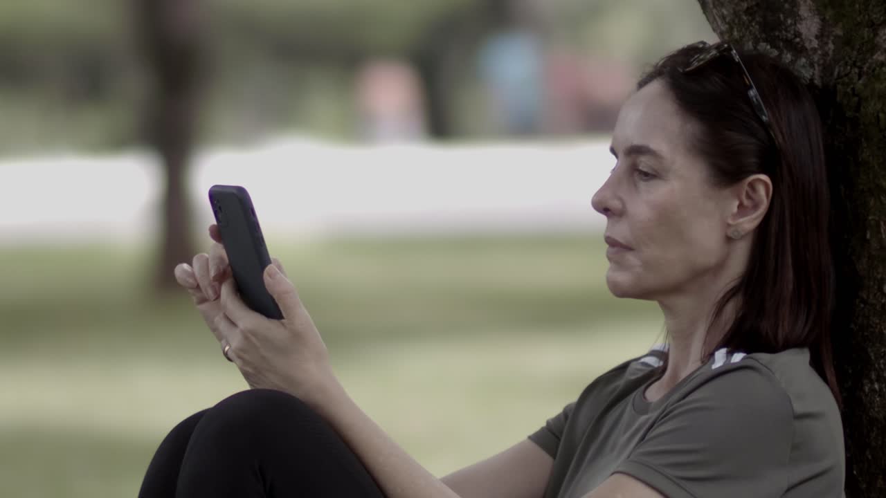 Pretty middle-aged woman, mobile phone habit, blurred background
