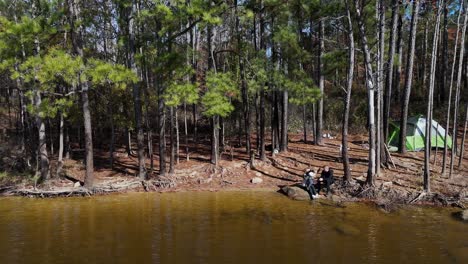 aerial view of a lake with a tent on the shore and people fishing emphasizing the tranquility of aerial view of a lake with a tent on the shore and people fishing emphasizing the tranquility of camping and nature