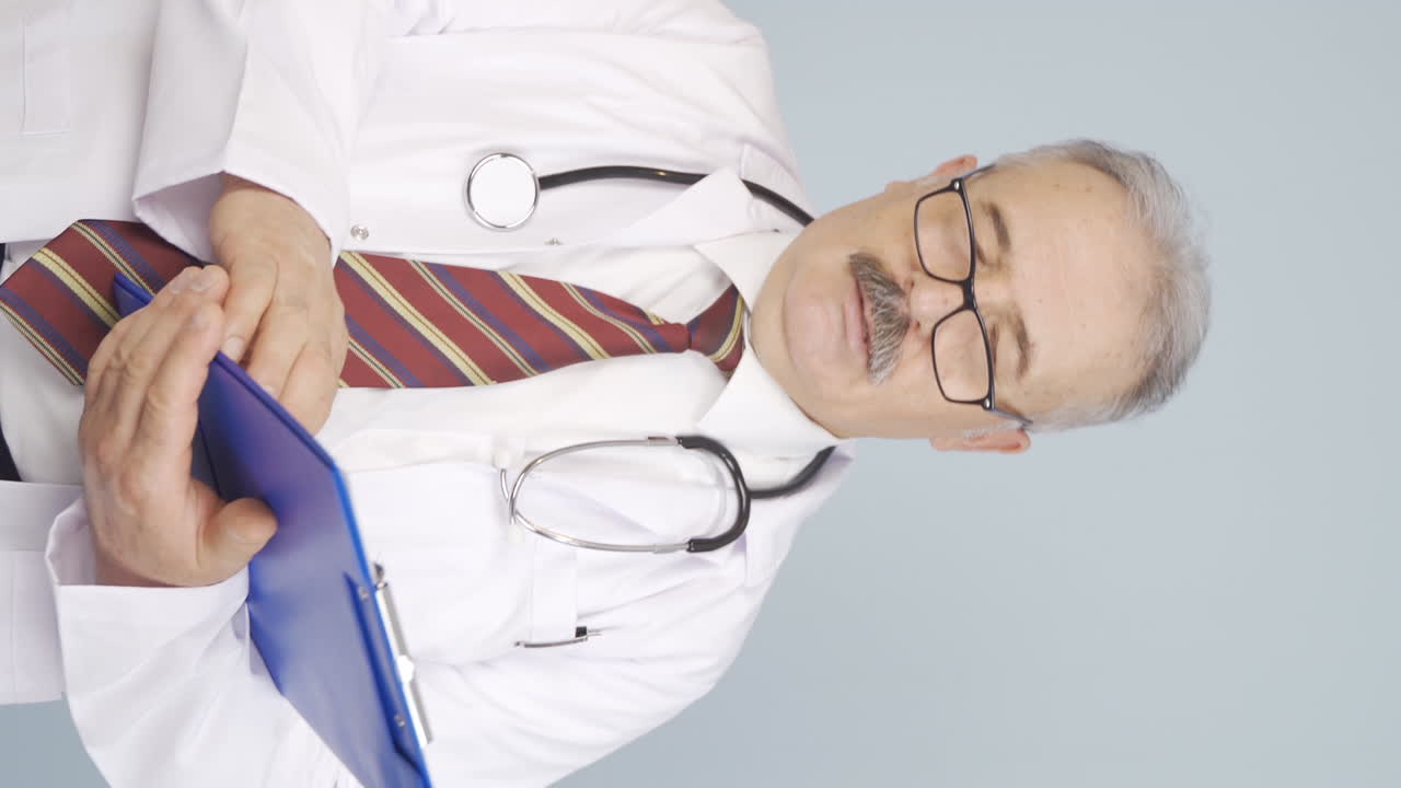 Vertical video of Old doctor with occupational fatigue.