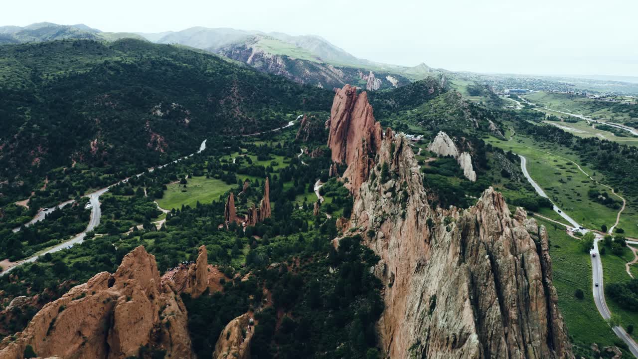 Drone shot of Garden of the Gods surrounded by Colorado's green valleys