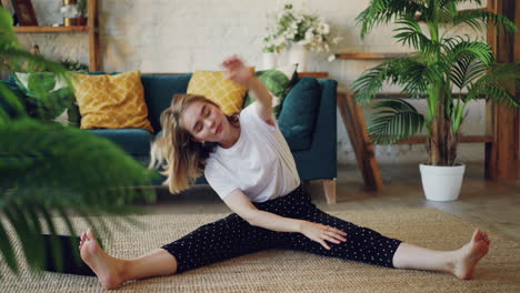 woman stretching at home with laptop