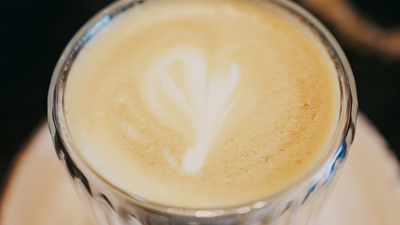 Close up of a glass cup with a latte at a cafe