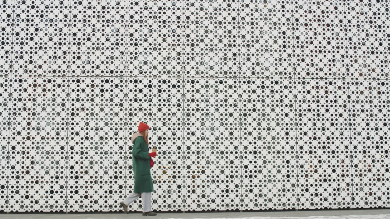 Woman walking by a modern building in winter