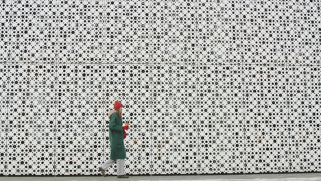 woman walking by a modern building in winter