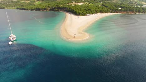 Una-Vista-Aérea-Muestra-A-Los-Turistas-Disfrutando-De-La-Playa-De-Zlatni-Rat-En-La-Isla-De-Brac,-Croacia