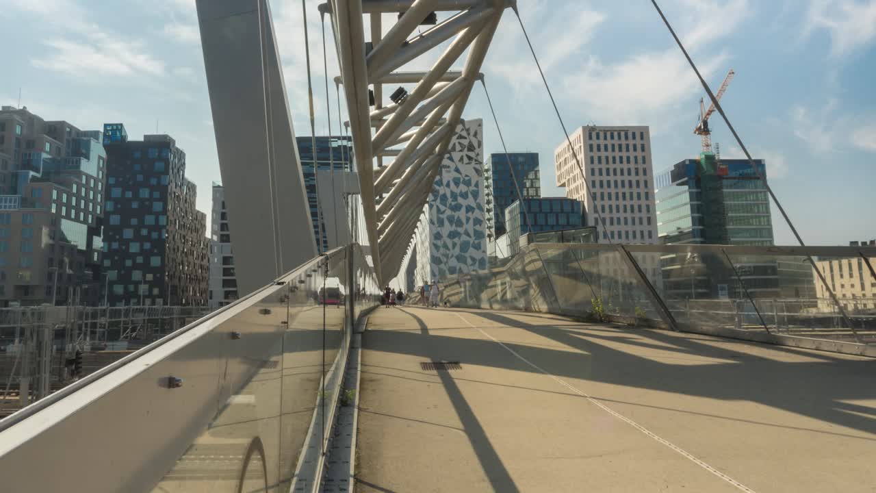 Time lapse: people walking Oslo Akrobaten bru pedestrian bridge, slide zoom out