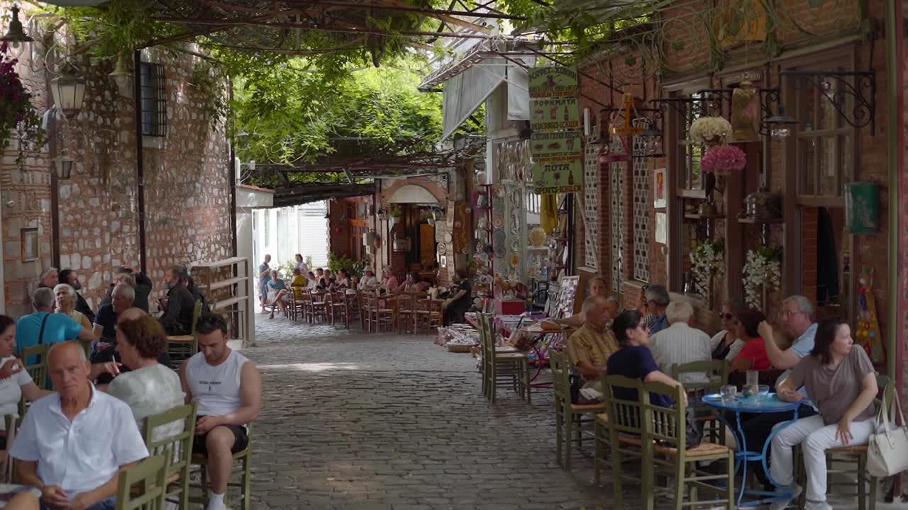 Tourist at traditional Greek taverna coffee shop with cosy ambience and surrounding in the old streets of Agiasos village, Gimbal shot