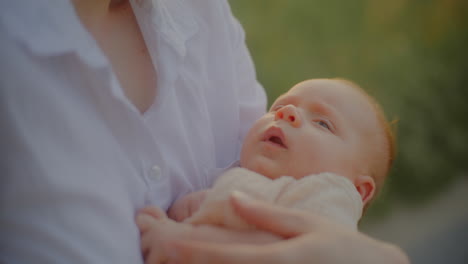 close-up baby boy held by mother at sunset