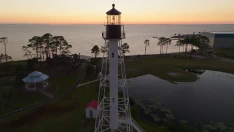 tight aerial orbit of orange sunset and beautiful coastal views at cape san blas lighthouse in port st